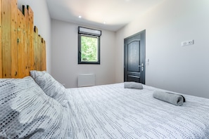 A bedroom with a bed, a radiator, a window, and a door. - Cottage 'Mas Delorme 2' with Shared Pool, Wi-Fi and Air Conditioning (Arles)