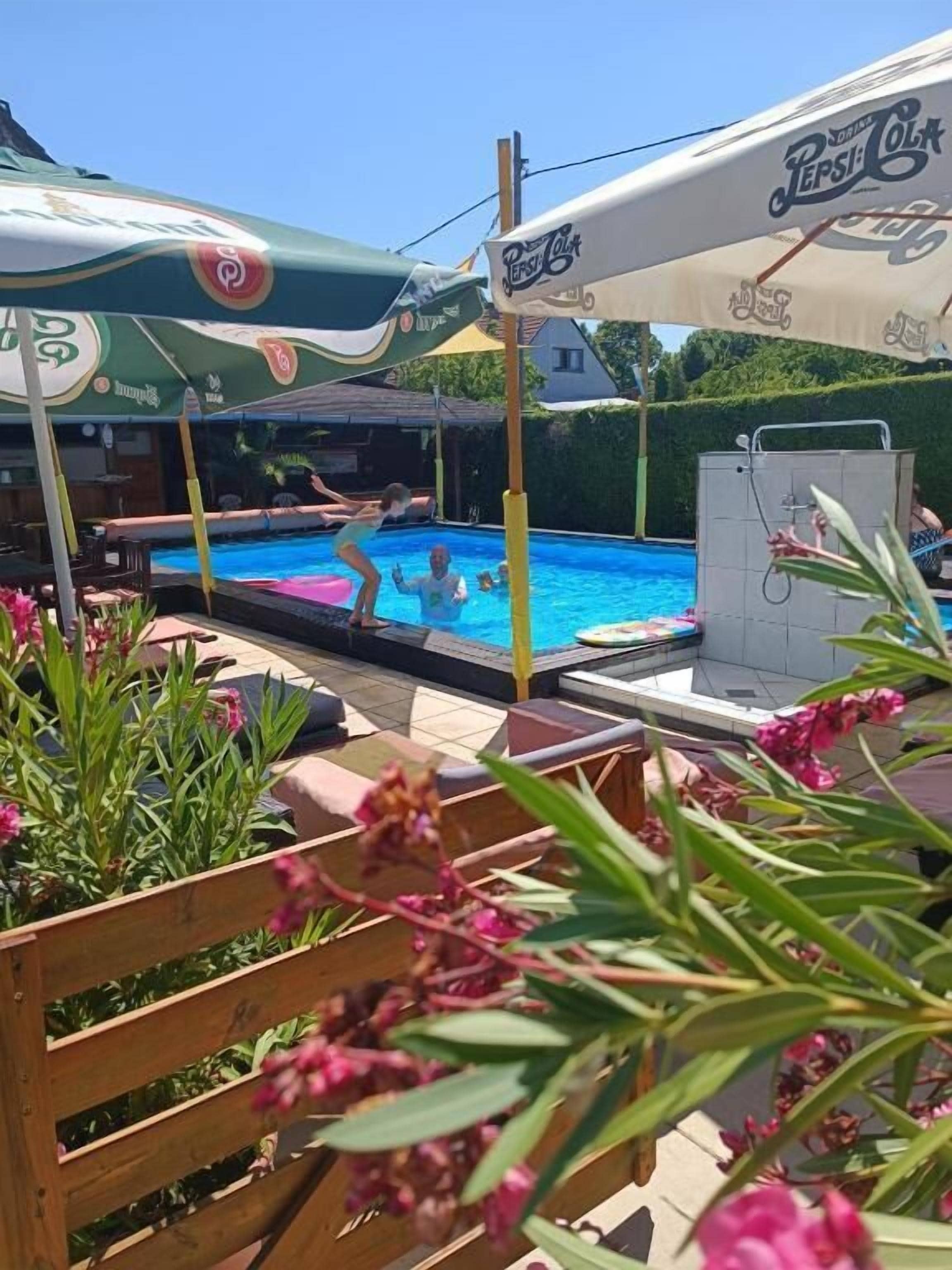 Una piscina al aire libre de temporada, sombrillas