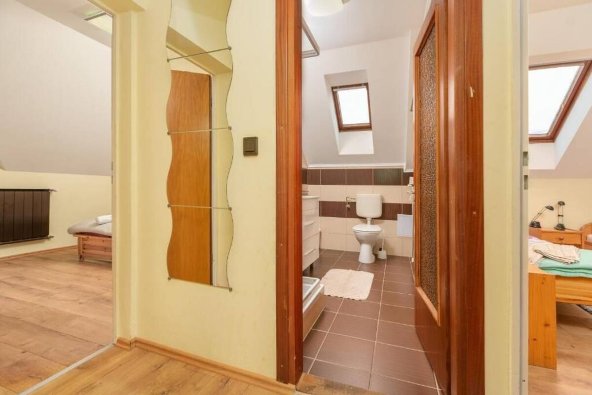 Un dormitorio con una cama de madera, una mesita de noche pequeña y una ventana.