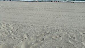 A wide sandy beach with footprints and a clear blue sky. - Oceanfront•Steps to beach•Pool view•Sleeps 6 (Myrtle beach)