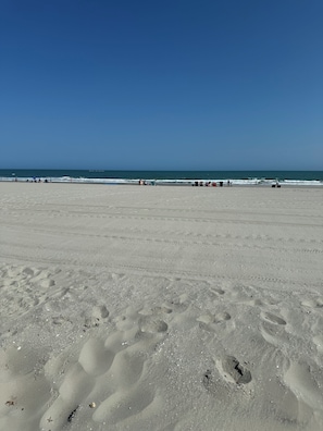 A wide sandy beach with footprints and a clear blue sky. - Oceanfront•Steps to beach•Pool view•Sleeps 6 (Myrtle beach)