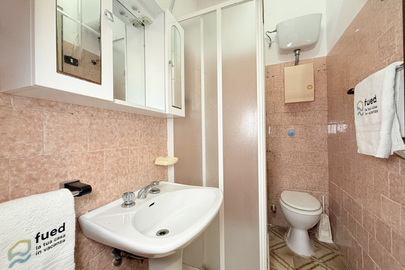A bathroom with a sink, toilet, and mirror.