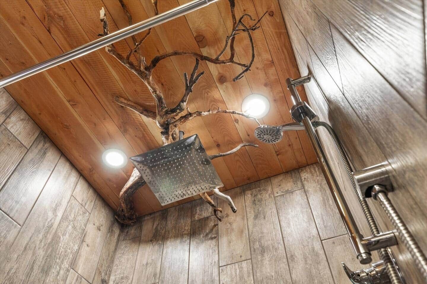 A shower with a wooden wall design, a metal showerhead, and a visible plumbing fixture.