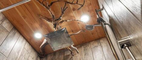 A shower with a wooden wall design, a metal showerhead, and a visible plumbing fixture.
