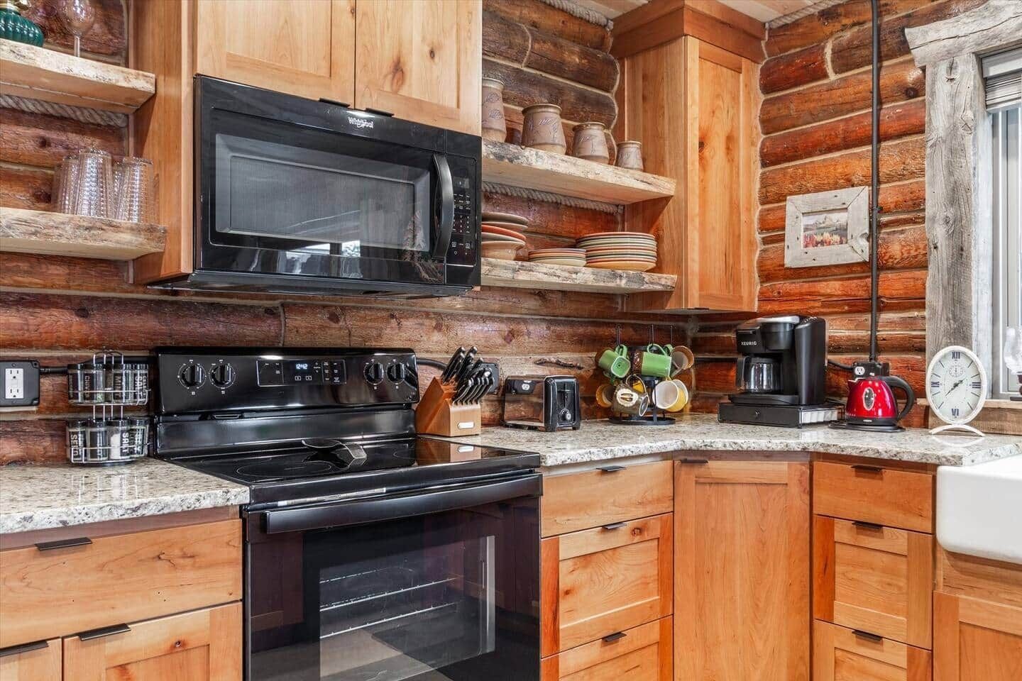 A kitchen with wooden cabinets, a black microwave, a stove, and various kitchen utensils.