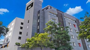 A modern hotel with a prominent tower labeled "TOWNHOUSE" and multiple windows. - Deluxe With Twin Bed Balewadi High (Pune)