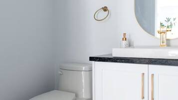 A bathroom with a toilet, a sink with a mirror, and a cabinet.