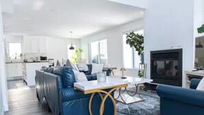 Un salon moderne avec un canapé, une table basse et une cheminée.
