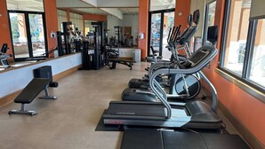 A gym with treadmills, weight machines, and benches. - 3BR Townhome at Regal Oaks Near Disney (Kissimmee)