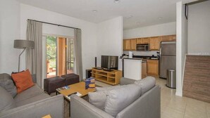 A modern apartment with a living room, dining area, and kitchen. - 3BR Townhome at Regal Oaks Near Disney (Kissimmee)