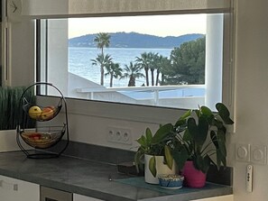 A kitchen with a fruit basket, potted plants, and a view of the sea through a window. - ROOFTOP VILLA WITH SEA VIEW/BEACHES WITHIN WALKING DISTANCE (Carqueiranne)