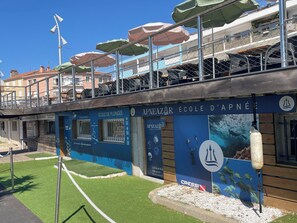 A building with a blue facade, signage for 'APNEAZAR ÉCOLE D'APNÉE,' and a Cressi logo. - ROOFTOP VILLA WITH SEA VIEW/BEACHES WITHIN WALKING DISTANCE (Carqueiranne)