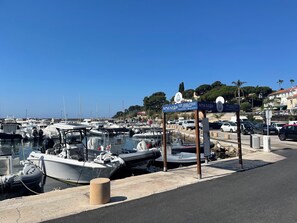 A marina with boats docked, a signboard, and a road with cars. - ROOFTOP VILLA WITH SEA VIEW/BEACHES WITHIN WALKING DISTANCE (Carqueiranne)