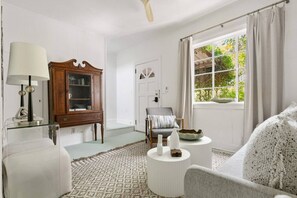 A room with a wooden cabinet, a chair, a round white table, and a window with curtains. - ~NEW~ Charming Guesthouse Near King St • Walk to Historic District • 30+ Stays (Charleston)