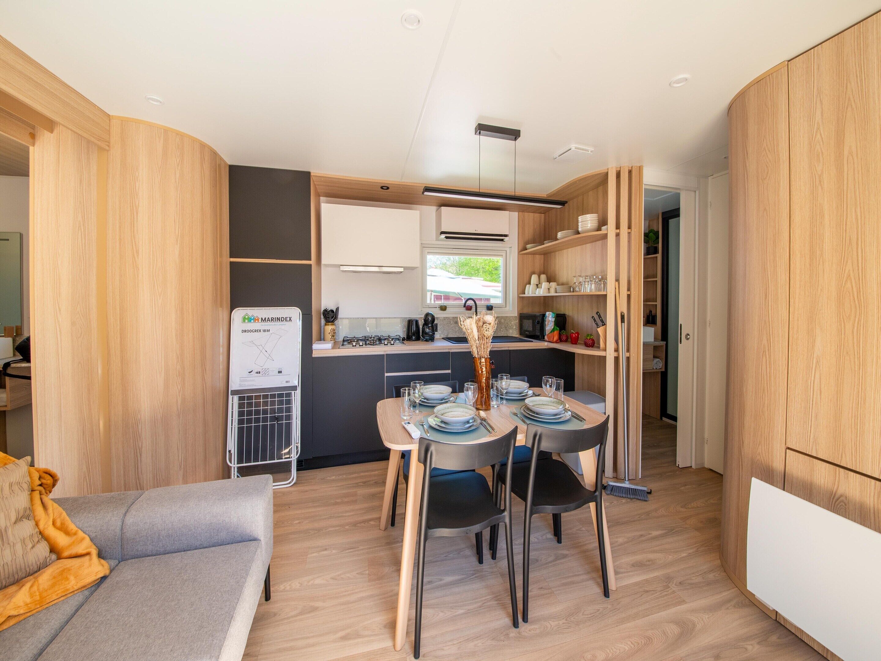 A compact living space with a kitchenette, dining area, and a sofa.