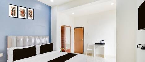 Una habitación de hotel con una cama, un escritorio y un espejo.