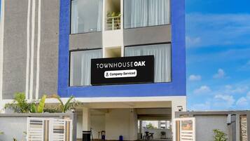 A modern building with a sign reading 'TOWNHOUSE OAK' and a company-serviced label.
