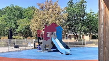 A playground with a slide and a climbing structure.