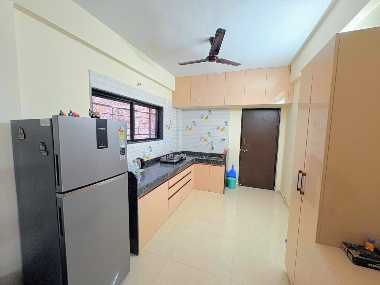 A kitchen with a refrigerator, stove, and cabinets.