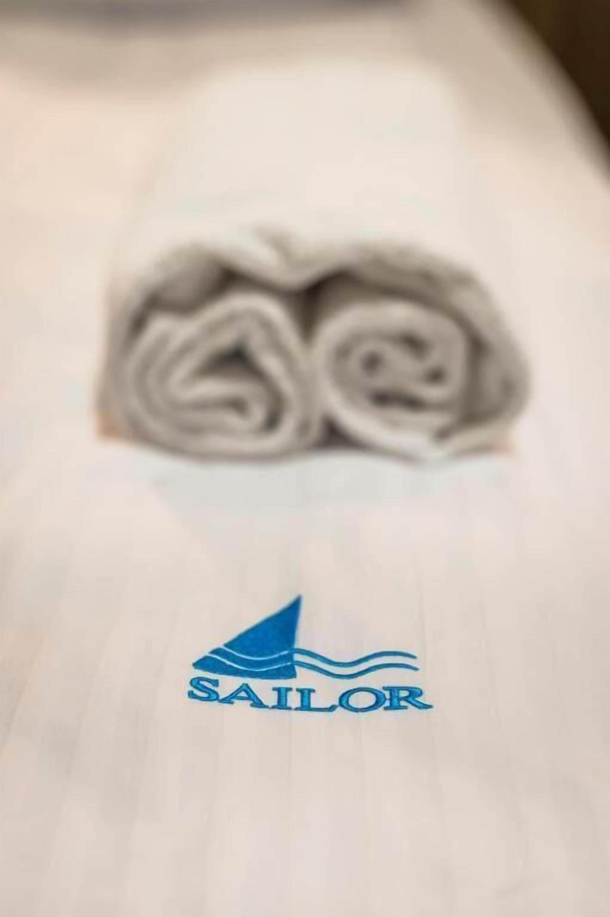 A logo with a sailboat and the word 'SAILOR' on a plain surface.