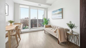 Un apartamento moderno con comedor, sofá y ventana grande con vistas.