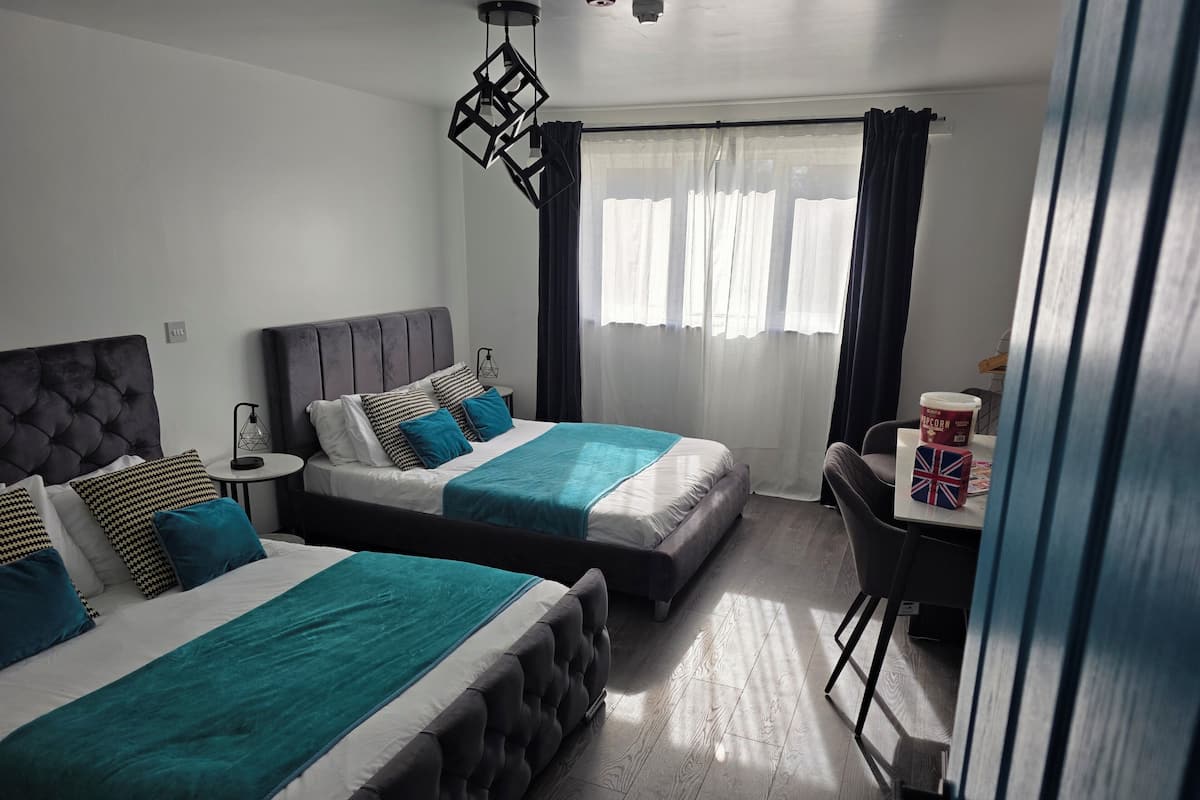 A hotel room with two beds, a small table with a cup of popcorn, and a chair.