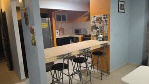 A kitchen with a bar area, a refrigerator, and a tiled backsplash. - Villa Acapulco Diamond (Acapulco de Juárez)