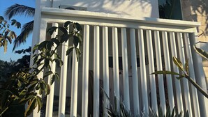 A modern building with a white facade, a balcony with vertical railings, and a small window. - Villa Acapulco Diamond (Acapulco de Juárez)