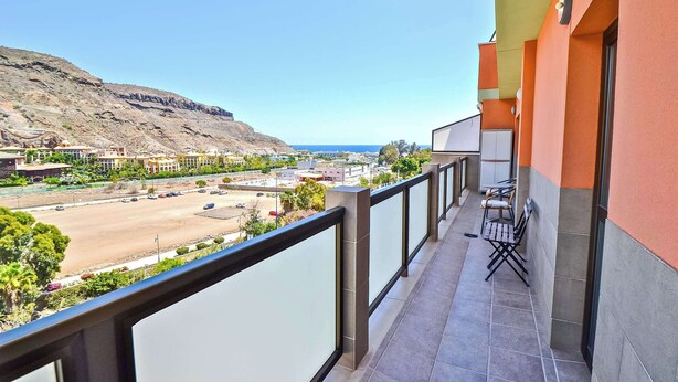A balcony with a view of a coastal road, a mountain, and the sea. - Holiday apartment in Mogan (Lomo Quiebre)