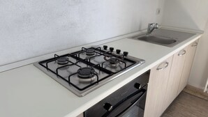 Une cuisine équipée d’une cuisinière à gaz, d’un évier et d’un lave-vaisselle.