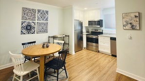 A dining area with a round table, chairs, and a rug.