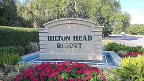 A sign for Hilton Head Resort with a landscaped garden in front.