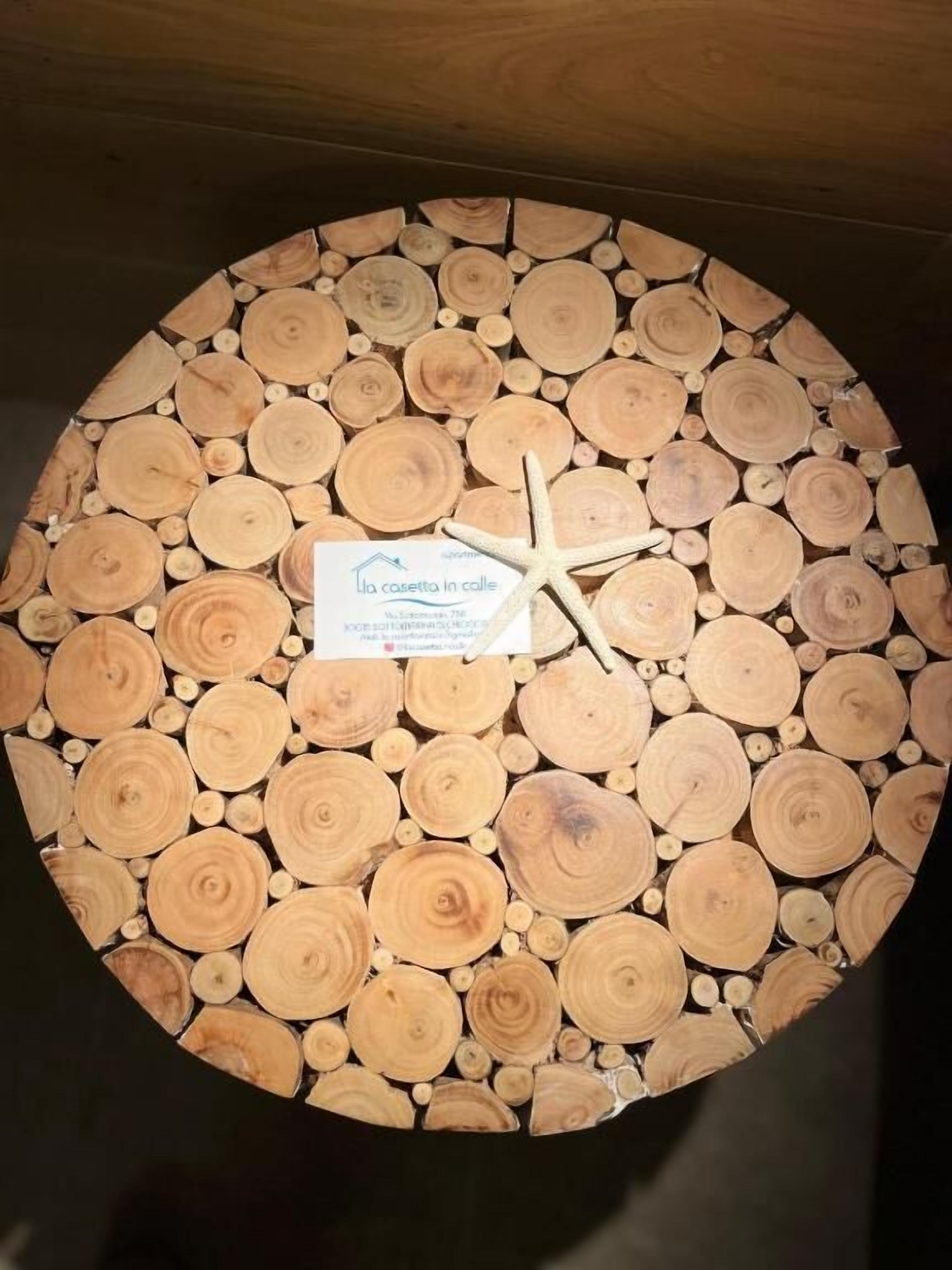 Una pieza decorativa de madera circular con un adorno de estrella de mar y una etiqueta.