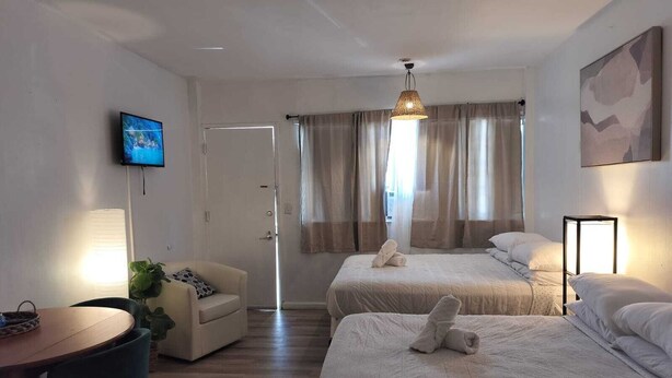 A hotel room with two beds, a TV, a desk, and a chair. - Authentic Stay in Little Havana  6 (Miami)