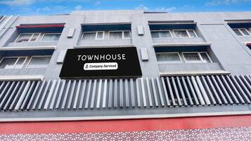 A building with a sign reading 'TOWNHOUSE' and a company-serviced logo.