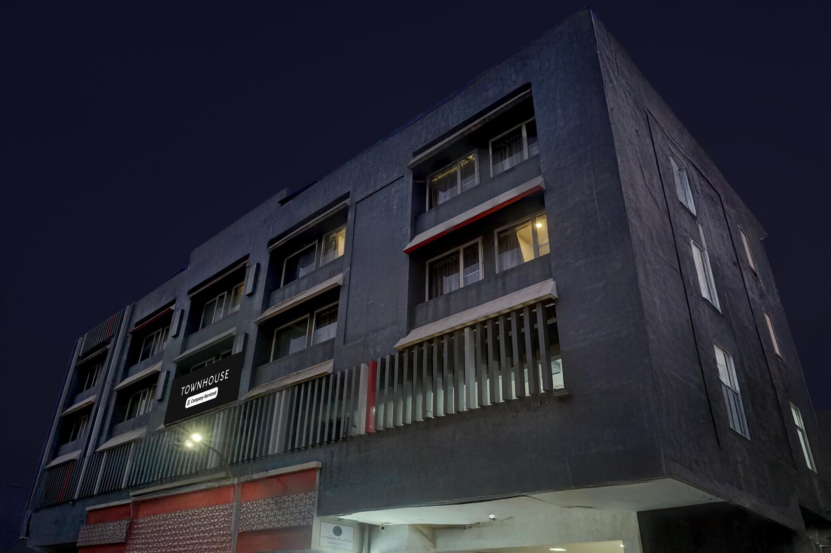 Un edificio moderno con varios pisos, balcones y un letrero que dice "TOWNHOUSE".