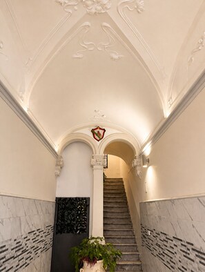 Eine prächtige Treppe mit aufwendigen Details an der Decke und einem Wappen.