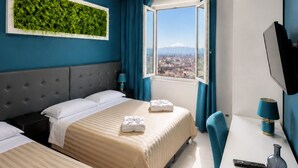 Une chambre d’hôtel avec deux lits, un bureau, une télévision et une fenêtre donnant sur la ville.