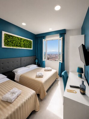 Ein Hotelzimmer mit zwei Betten, einem Schreibtisch, einem Fernseher und einem Fenster mit Blick auf die Stadt.