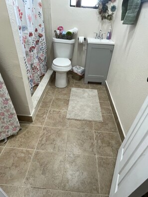 Ein Badezimmer mit Toilette, Waschbecken und Duschvorhang.