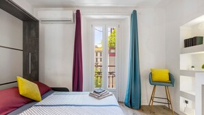 A bedroom with a bed, a chair, a window with curtains, and a bookshelf. - La Casa Delle Meraviglie – Porta Romana, Milan (Milano)