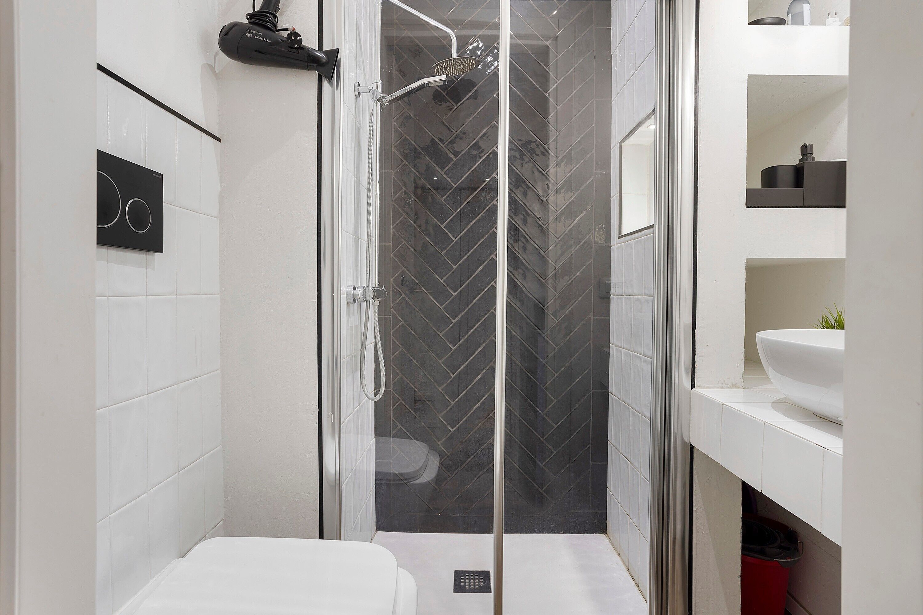 A modern bathroom with a shower, toilet, and sink.