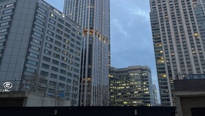 Ein Hochhaus mit modernem architektonischen Design, das durch eine markante vertikale Struktur und zahlreiche Fenster gekennzeichnet ist.