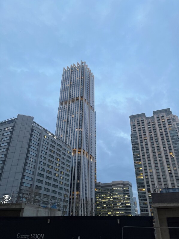 A high-rise building with a modern architectural design, featuring a prominent vertical structure and numerous windows.
