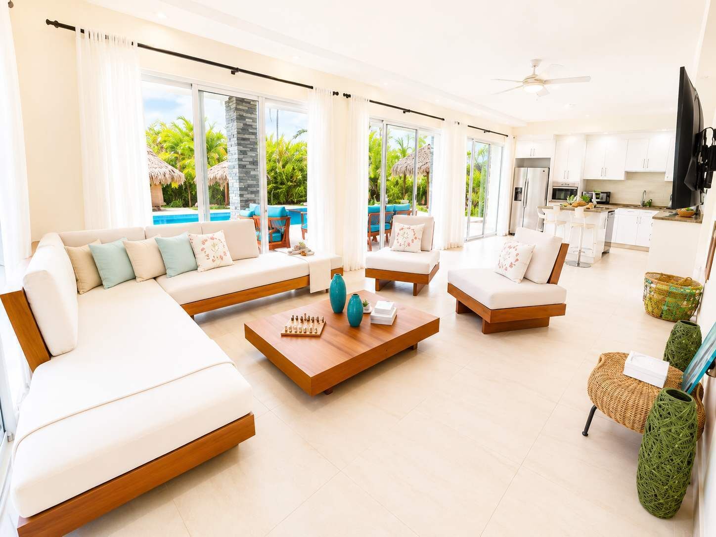 A modern living room with a pool view, a kitchen area, and a dining space.