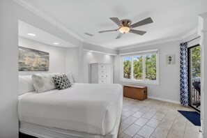 A bedroom with a bed, ceiling fan, window, and a view of the outdoors. - Award-Winning Resort Amenities | Port O' Call G203 (Isle Of Palms)