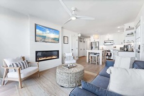 Ein modernes Wohnzimmer mit Kamin, Essbereich und Küche.