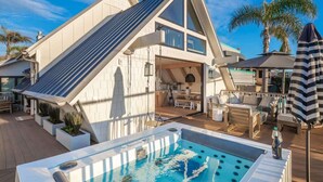 A modern house with a pool, outdoor seating, and a sloped roof. - Neptune Ocean View Masterpiece (Encinitas)
