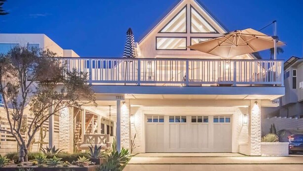A two-story house with a balcony, a garage, and a well-lit driveway. - Neptune Ocean View Masterpiece (Encinitas)