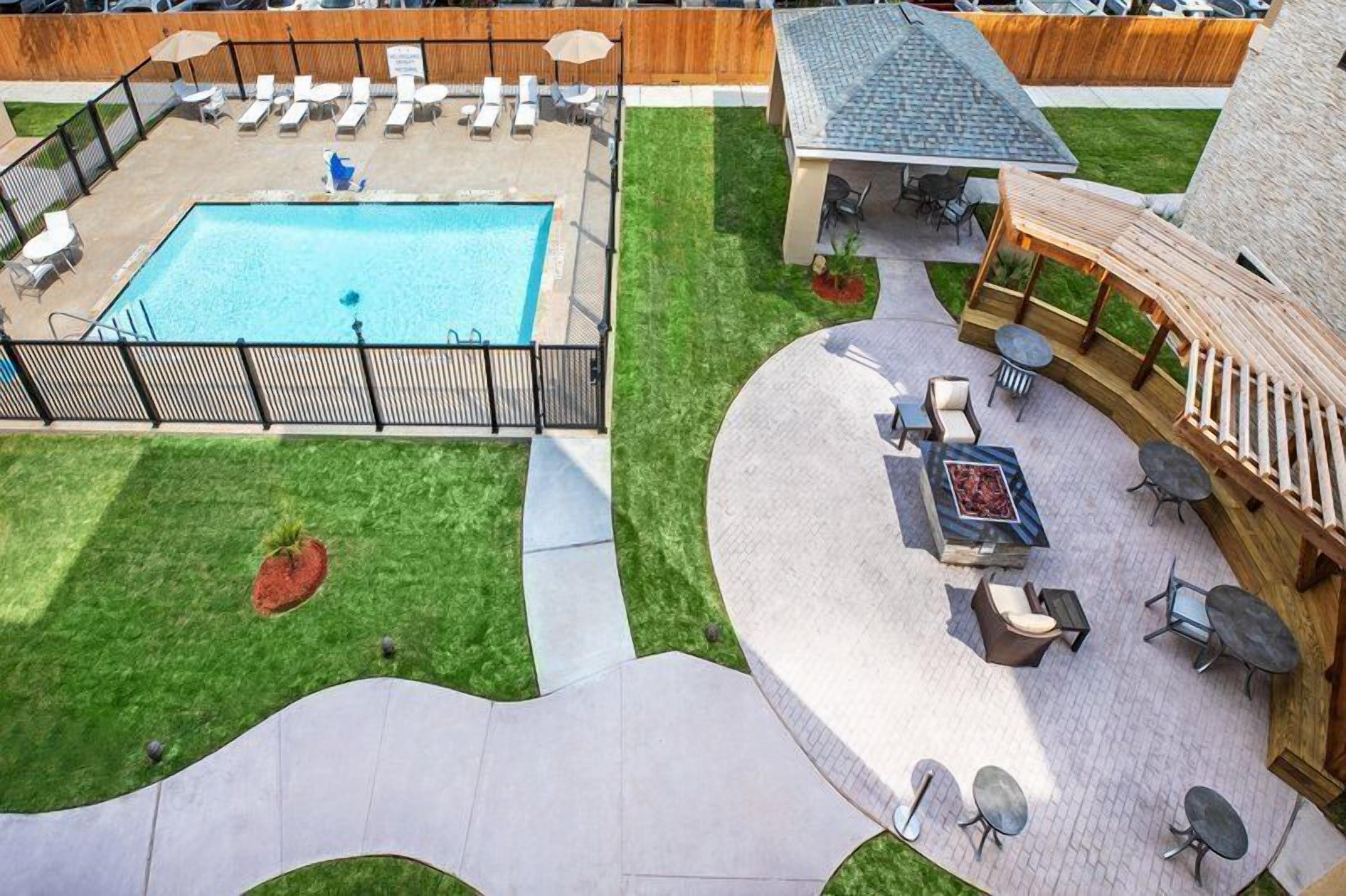 A pool area with lounge chairs and a barbecue.